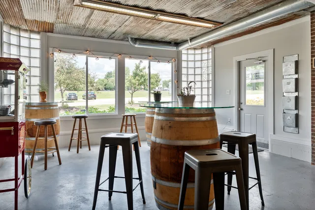 a backyard of a house with table and chairs under an umbrella