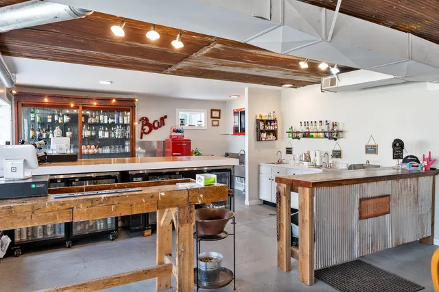 a large living room with stainless steel appliances a lot of counter space and a couch