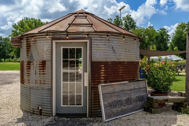a view of a patio with table and chairs under an umbrella with a large tree