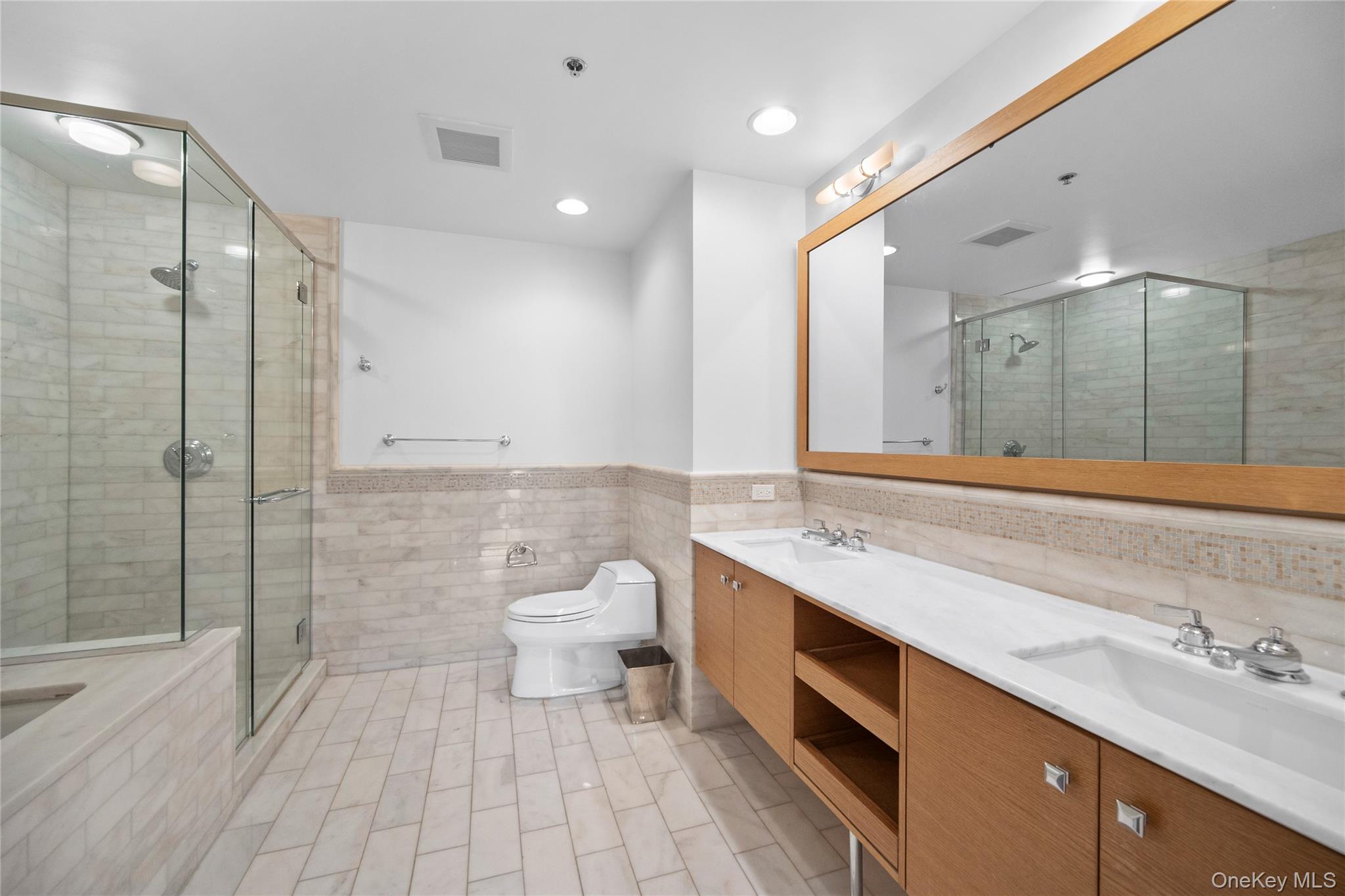 1 Renaissance Square, Unit 10C White Plains, NY 10601 - Photo 16 of 28 Bathroom featuring tile walls, double vanity, a stall shower, toilet, and a bathtub