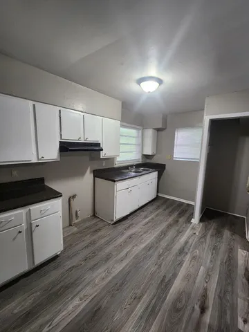 a kitchen with granite countertop a stove top oven and cabinets
