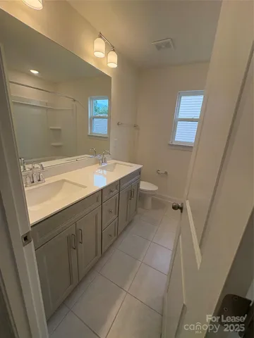 a spacious bathroom with a sink a toilet and a mirror