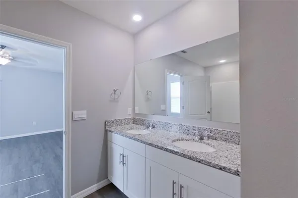 a bathroom with a granite countertop sink and a mirror