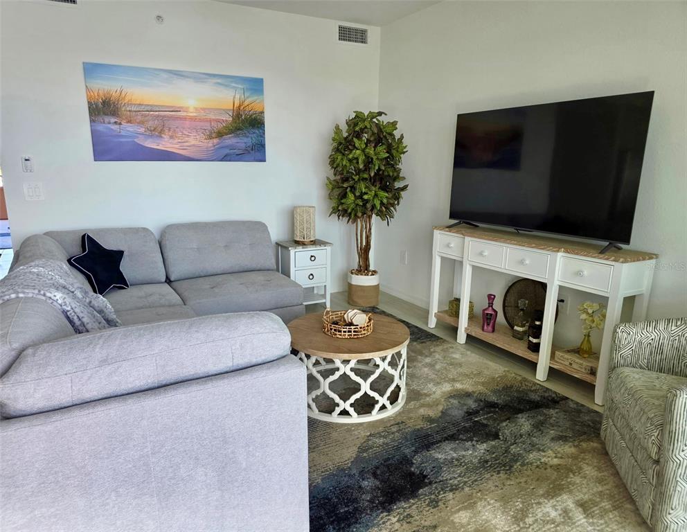 19116 Scallop Loop, Unit 303 Lakewood Ranch, FL 34211 - Photo 10 of 32 a living room with furniture a fireplace and a flat screen tv