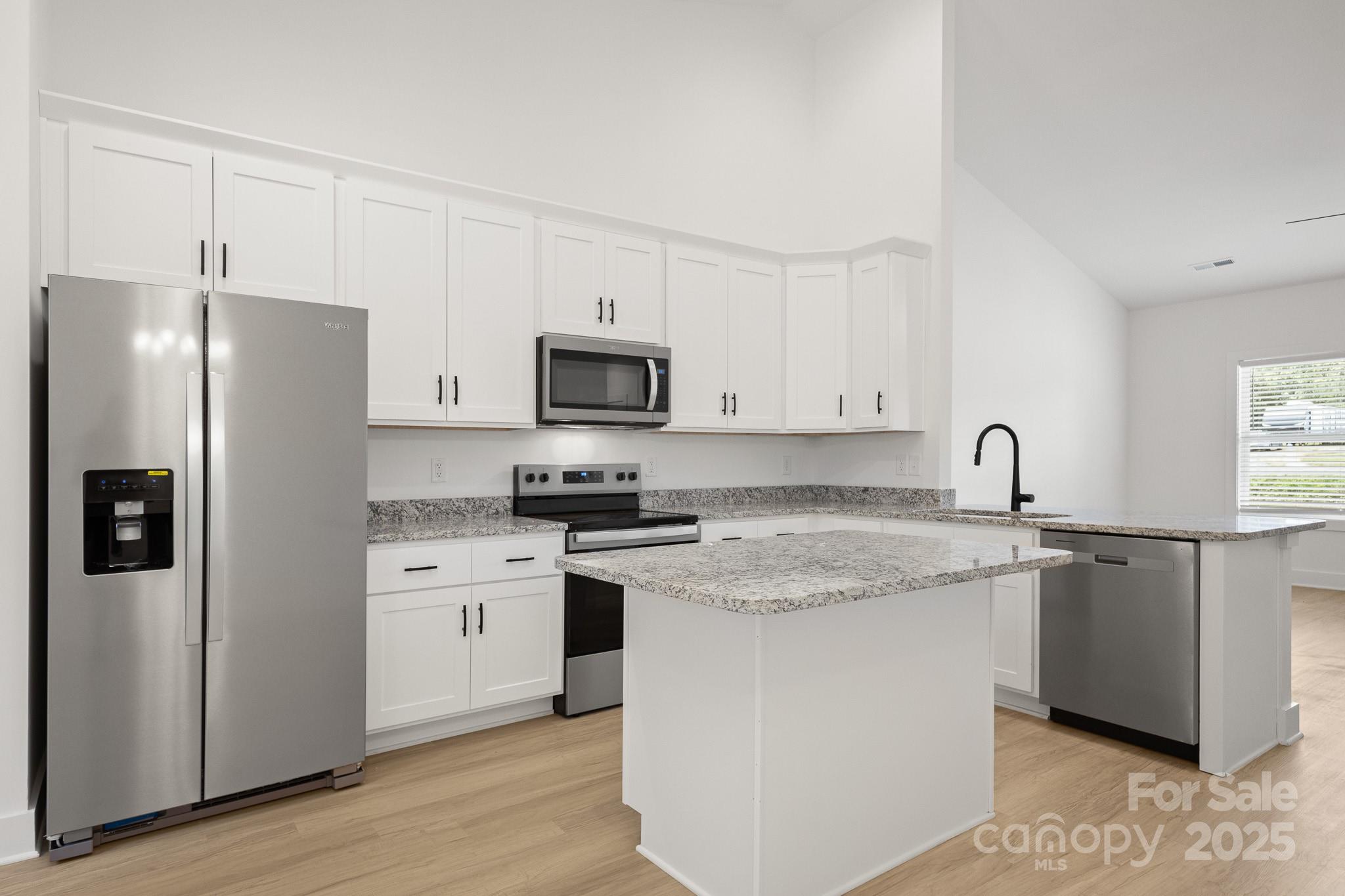 6155 Long Branch Road Salisbury, NC 28147 - Photo 11 of 35 a kitchen with stainless steel appliances granite countertop a stove a sink dishwasher a refrigerator and a stove with wooden floor