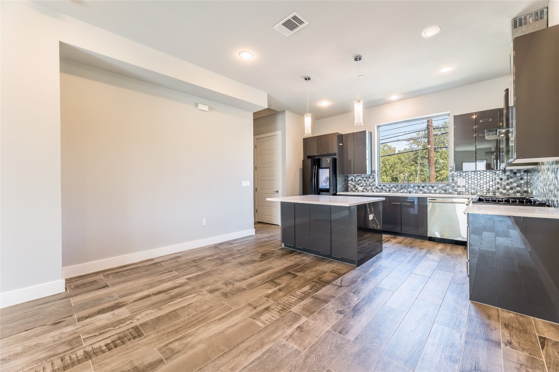 1417 Kramer Lane, Unit 9 Austin, TX 78758 - Photo 18 of 40 a large kitchen with a large counter top a sink stainless steel appliances and cabinets