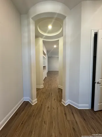 a view of a hallway with wooden floor and a mirror