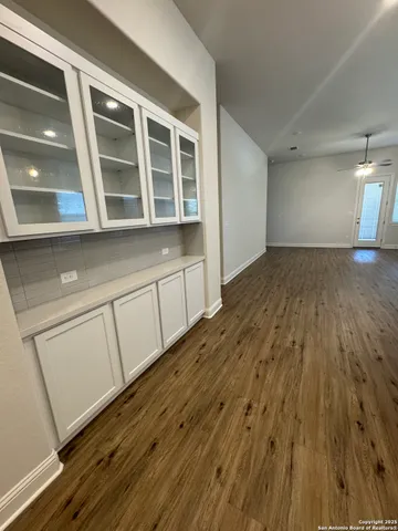 a view of an empty room with wooden floor and windows