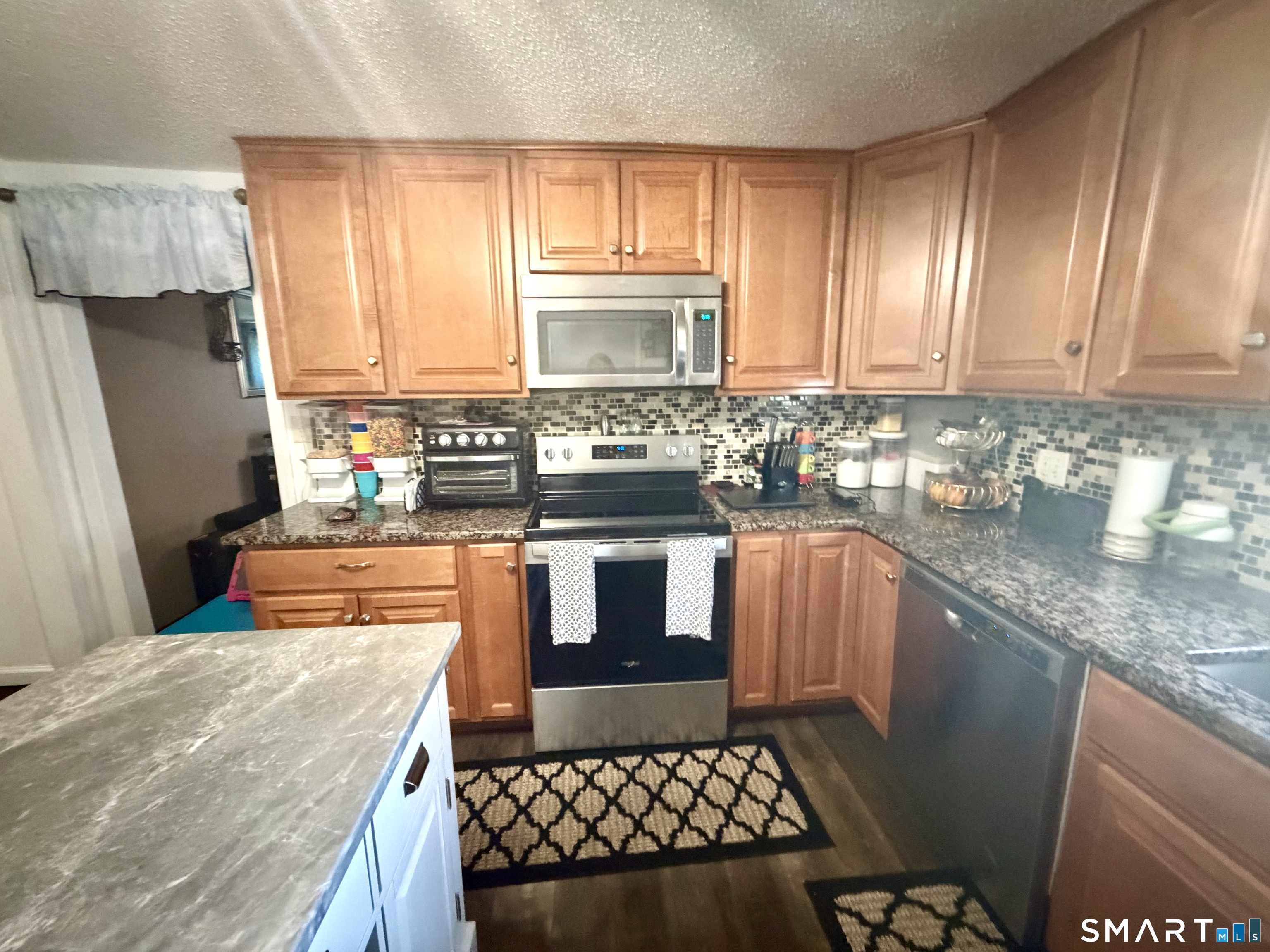 75 Elizabeth Avenue Bloomfield, CT 06002 - Photo 11 of 17 a kitchen with stainless steel appliances granite countertop a sink a stove a microwave a sink and cabinets