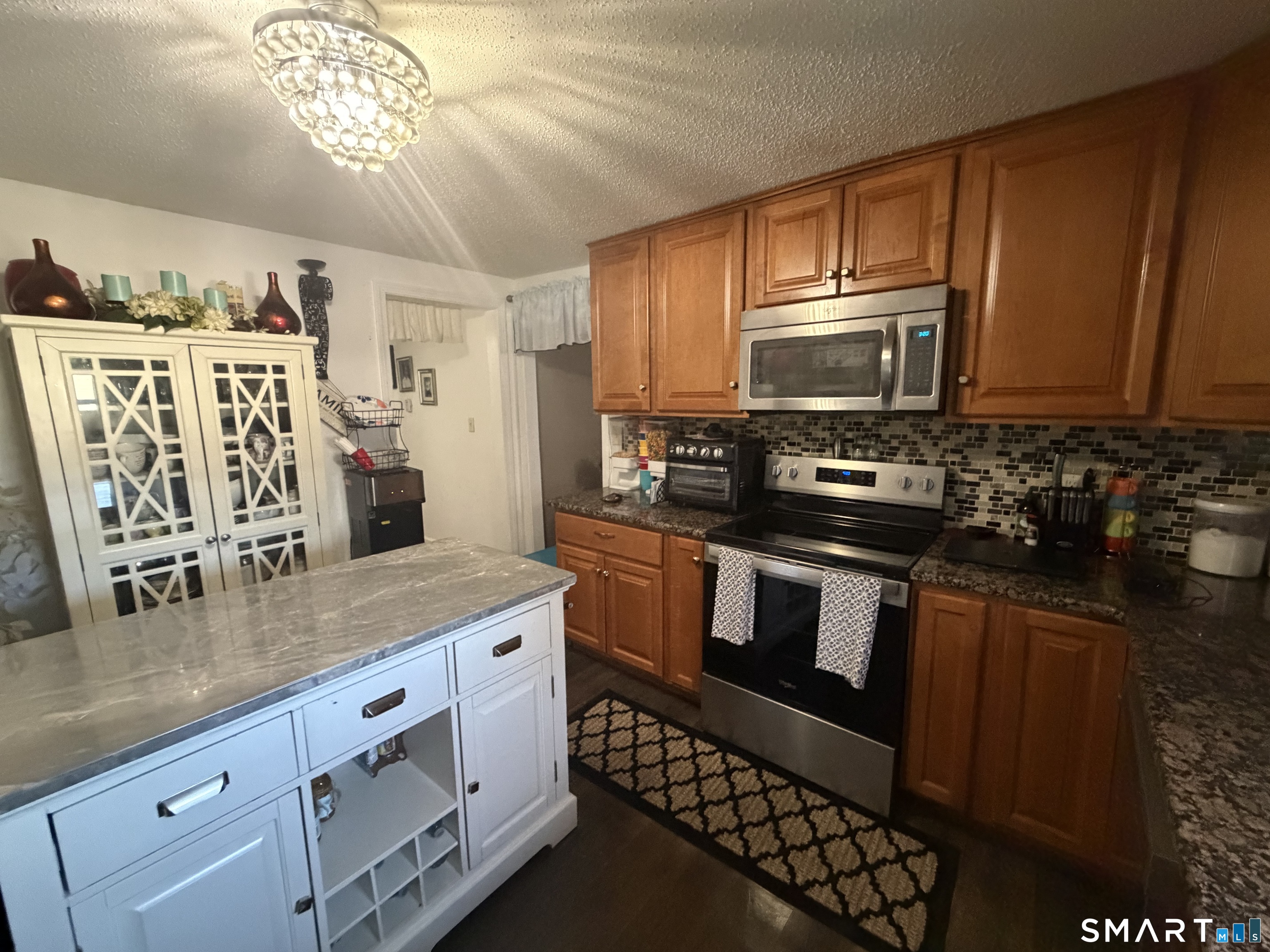 75 Elizabeth Avenue Bloomfield, CT 06002 - Photo 8 of 17 a kitchen with stainless steel appliances granite countertop a stove a microwave a sink and cabinets