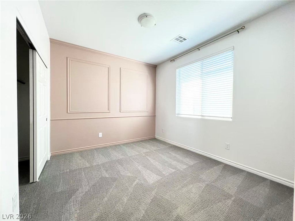 925 Bayberry Ridge Street Henderson, NV 89052 - Photo 23 of 27 A well-lit room with soft neutral carpeting and stylish wall molding awaits your personal touch.