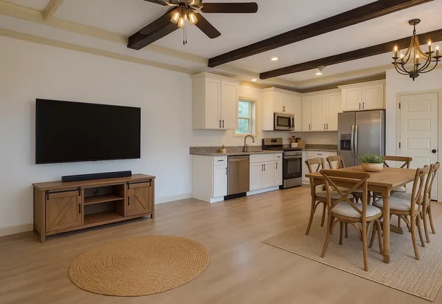a living room with a flat screen tv and kitchen view