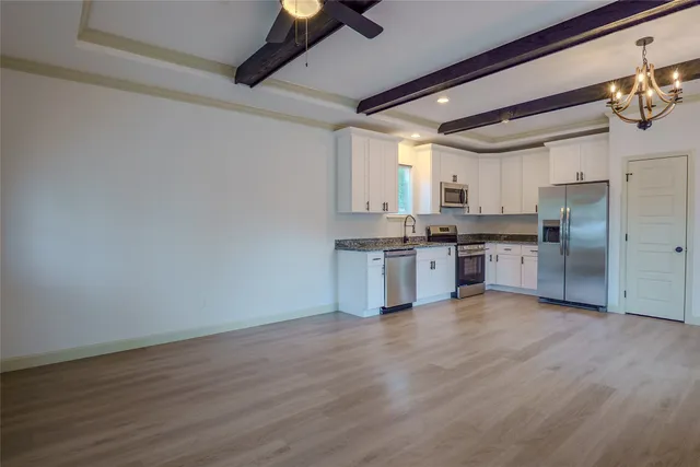a kitchen with stainless steel appliances a refrigerator and wooden floor