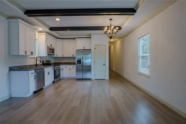 a kitchen with granite countertop a stove a sink and a refrigerator