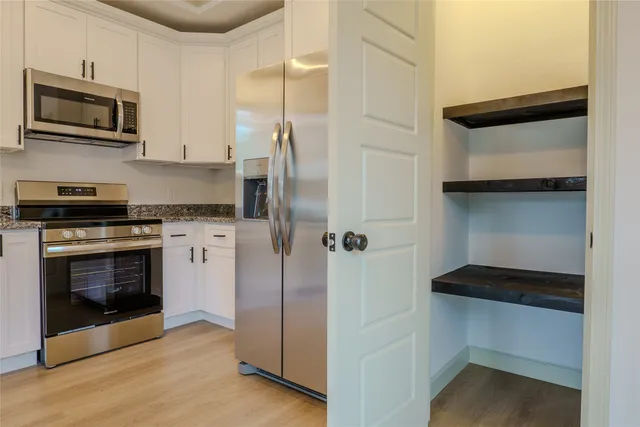a kitchen with a refrigerator and a stove top oven