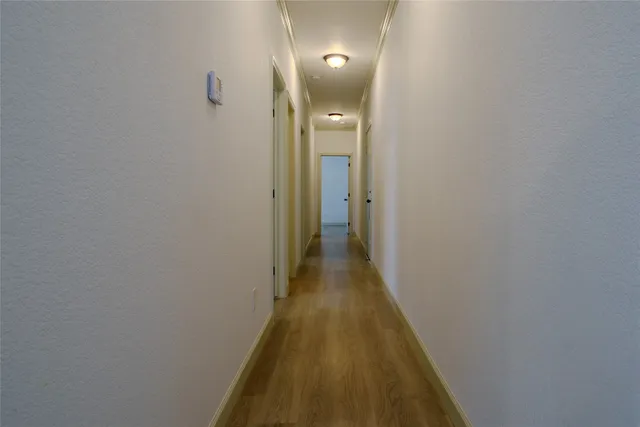 a view of a hallway with wooden floor