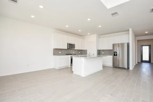 a large white kitchen with stainless steel appliances