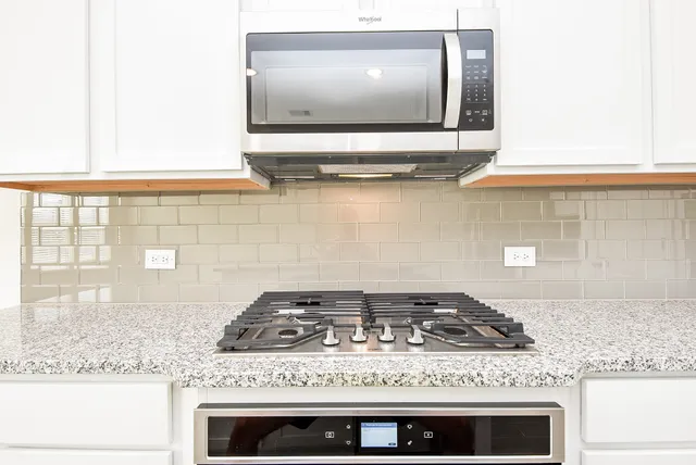 a stove top oven sitting inside of a kitchen