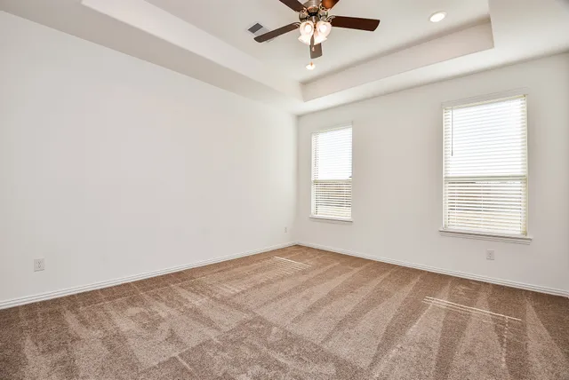 an empty room with a window and a fan