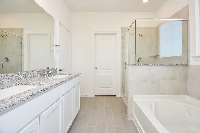 a bathroom with a granite countertop bathtub shower sink and mirror