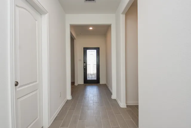 a view of a hallway with wooden floor