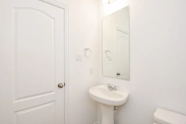a bathroom with a sink a toilet and mirror