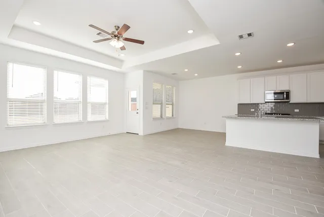 a view of an empty room with a kitchen