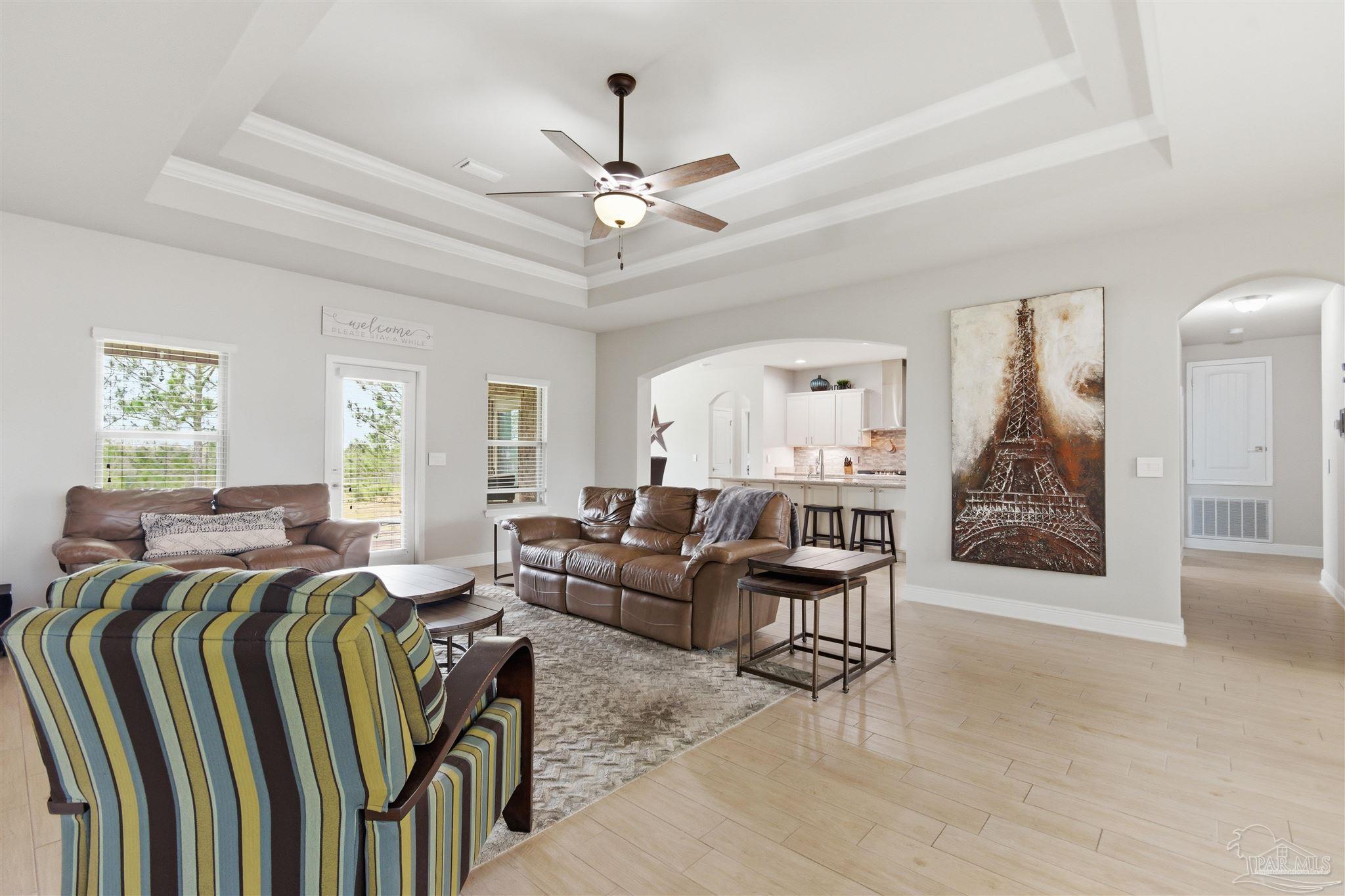 2677 Tulip Hill Road Pace, FL 32571 - Photo 15 of 35 a living room with furniture a chandelier and a flat screen tv
