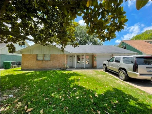a front view of a house with a garden and parking