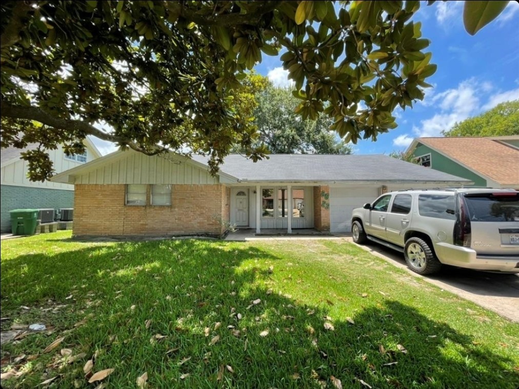 8623 Nairn Street Houston, TX 77074 - Photo 2 of 7 a front view of a house with a garden and parking