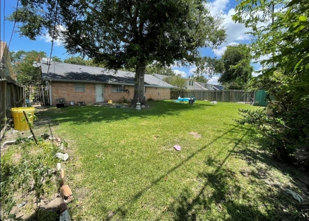 8623 Nairn Street Houston, TX 77074 - Photo 4 of 7 a backyard of a house with plants and large trees
