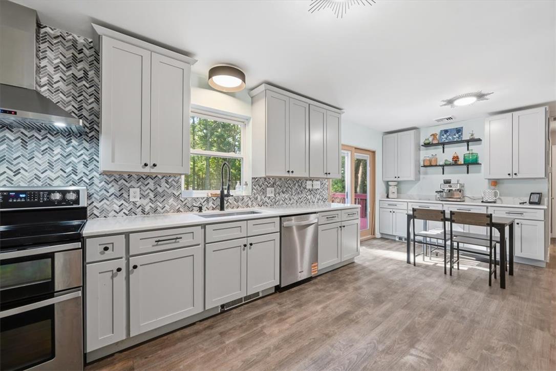 128 Chestnut Street Dingmans Ferry, PA 18328 - Photo 10 of 43 Clean lines and a chevron tile backsplash define this updated kitchen with modern amenities.