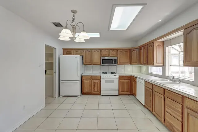 a kitchen with stainless steel appliances granite countertop a refrigerator a stove a microwave oven with white cabinets