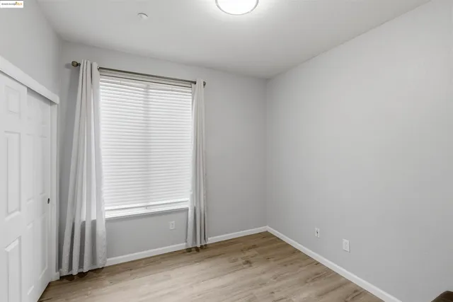 an empty room with wooden floor and closet