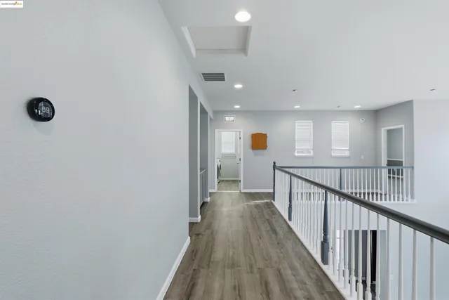 a view of a hallway with wooden floor and stairs