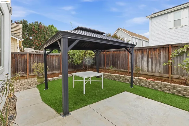 a backyard of a house with table and chairs