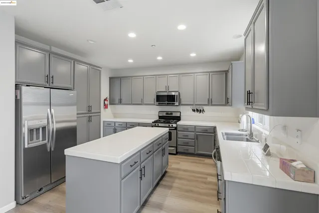 a kitchen with stainless steel appliances a sink stove and cabinets