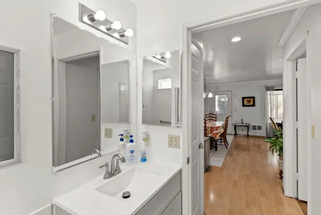 a kitchen with stainless steel appliances kitchen island granite countertop a refrigerator a sink a stove and white cabinets