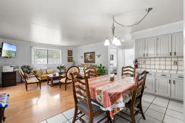 a very nice looking dining room with kitchen island stainless steel appliances a table and chairs