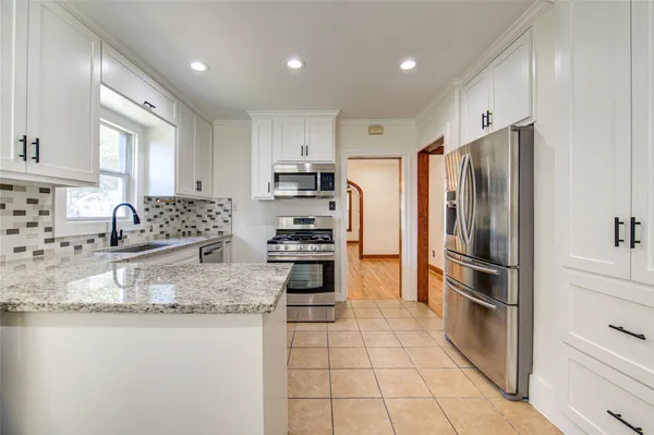 a kitchen with granite countertop a refrigerator and a sink
