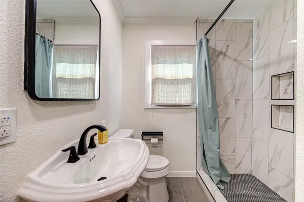 a bathroom with a sink a toilet and a mirror