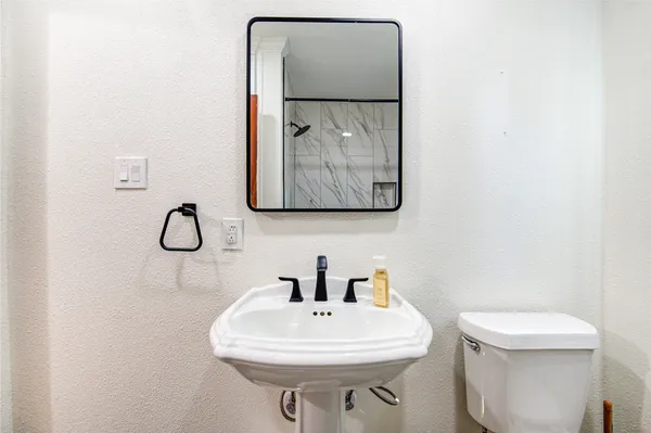 a bathroom with a toilet sink and mirror