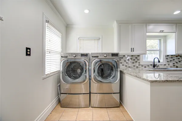 a utility room with sink dryer and washer
