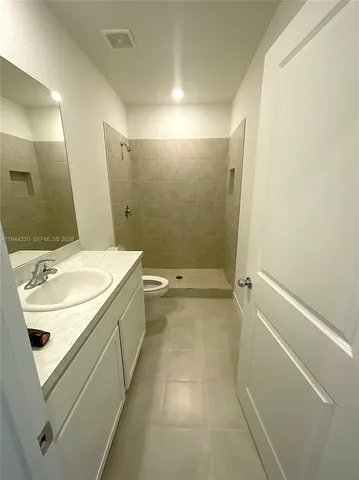 a bathroom with a sink a toilet and a mirror