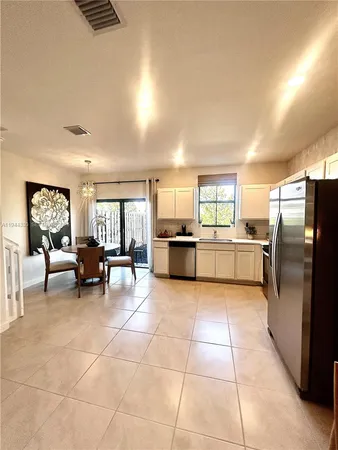 a large kitchen with a stove a refrigerator a dining table and chairs