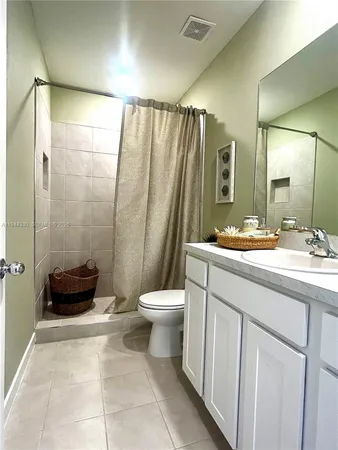 a bathroom with a double vanity sink toilet and shower