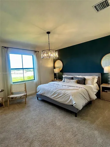 a spacious bedroom with a bed and a chandelier