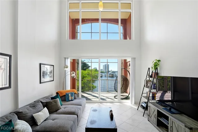 a living room with furniture a flat screen tv and a window
