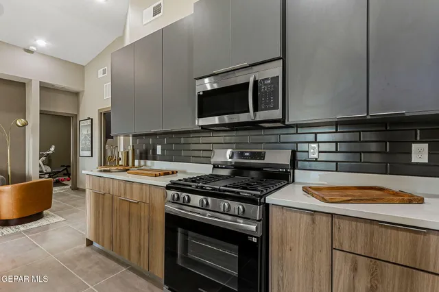 a kitchen with stainless steel appliances a stove a sink and a microwave
