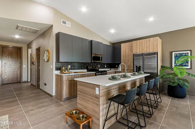 a kitchen with a sink a counter top space stainless steel appliances and cabinets